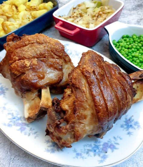 Two crispy-skinned eisbein on a plate next to a selection of vegetables. Eisbein Recipe, German Fried Potatoes, Chicken And Ham Pie, Beef Schnitzel, Ham Hock Soup, Sauteed Potatoes, Pork Knuckle, Ham Hock, Multi Cooker