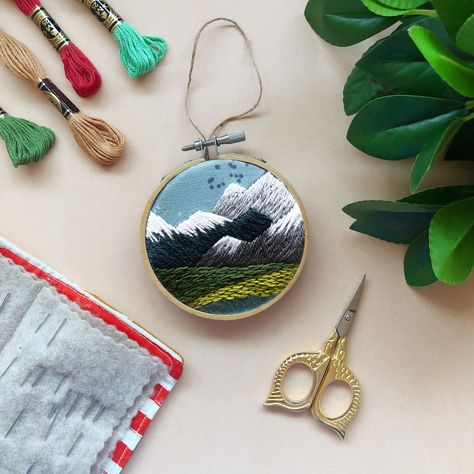 If you’ve seen me at a market over the past few weeks you know I have some new and reworked kits. Since my PNW pendant and pin kits were so beloved, I’ve also turned this design into an ornament!⁠ ⁠ It’s perfect for the coming holidays . You can make it as a treat for your tree or as a gift, or give it to your crafty Seattle loving friend! #pnw #embroidery #ornament #seattle #mountainlover #landscapeart #mcreativej Pnw Mountains, Wood Embroidery, Diy Beginner, Needlecraft Kits, Mini Embroidery, December Crafts, Beginner Embroidery, Ornament Craft, Everyday Decor