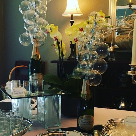 Champagne bubble centerpieces for a bridal shower.  Glass ornaments threaded onto a dowel then set into the empty champagne bottles! Champagne Theme Centerpieces, Bubbles And Bowties Theme, Bubbles Centerpiece, Champagne Bottle Centerpiece Ideas, Champagne Bottle Centerpiece, Champagne Centerpiece Ideas, Champagne Centerpieces, Bubble Centerpieces, Nye Wedding Centerpieces