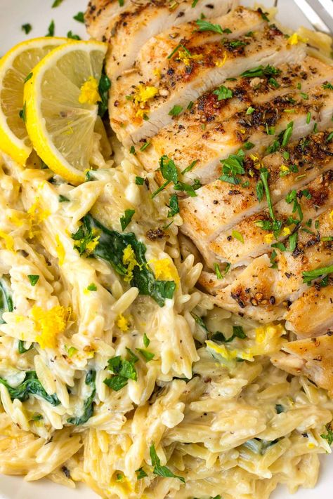 Lemon Chicken Orzo! This creamy one pot lemon chicken orzo is perfect for weeknights, and an amazing comfort food recipe. The orzo is tender, and it's tossed with fresh lemon and spinach. Greek Chicken And Lemon Rice One Pot, One Pan Lemon Chicken And Orzo, Lemon Orzo With Chicken, Lemon Chicken Orzo Bake Boursin, Orzo Chicken Thigh Recipes, Chicken Orzo Spinach Recipes, Lemon Chicken Orzo Crockpot Recipes, Creamy Parmesan Chicken And Orzo, Sides For Lemon Chicken