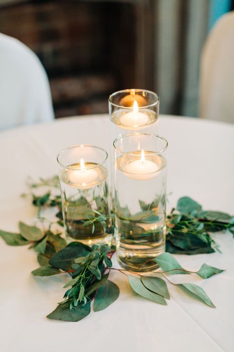 Floating candles with greenery wedding reception Floating Candle Centerpieces Eucalyptus, Floating Tea Candle Centerpieces, Ikea Floating Candle, Floating Candles For Wedding, Simple Cheap Centerpieces Wedding, Inexpensive Reception Centerpieces, 3 Floating Candle Centerpieces Wedding, Floating Candle With Greenery Centerpieces, Candle Round Table Centerpiece