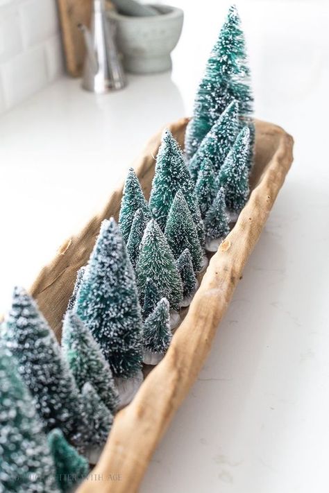 a long wooden tray with lots of green bottle brush trees is a pretty and lovely centerpiece for Christmas Rustic Home Inspiration, Christmas Centrepiece Ideas, Dough Bowl Centerpiece, Winter Centerpieces, Coastal Interior, Bottle Brush Christmas Trees, Tree Centerpieces, Christmas Tours, Christmas Mantel Decorations