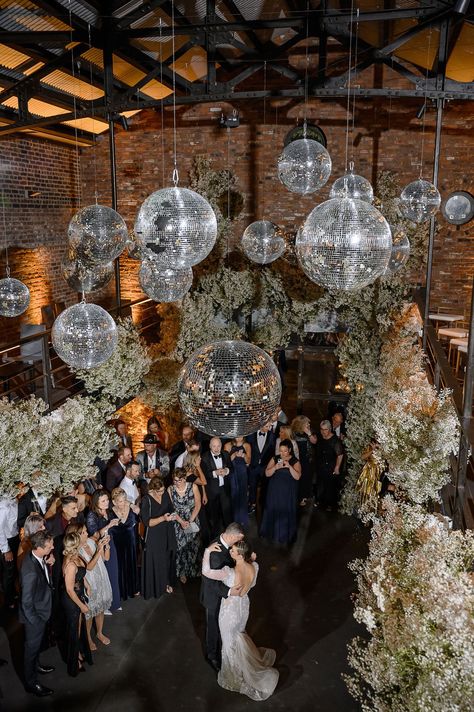 The couple's first-dance under the disco balls was to an acoustic version of “Rather Be” by Marc Scibilia that transitioned into the original Clean Bandit vers… Wedding Reception Disco Balls, Disco Ball And Chandelier Wedding, Disco Ball Decorations Wedding, Disco Ball Ceiling Decor Wedding, Wedding Party Decorations Indoor, Disco Balls Wedding Decor, Disco Ball Dance Floor Wedding, Disco Balls Hanging From Ceiling, Disco Ball Reception