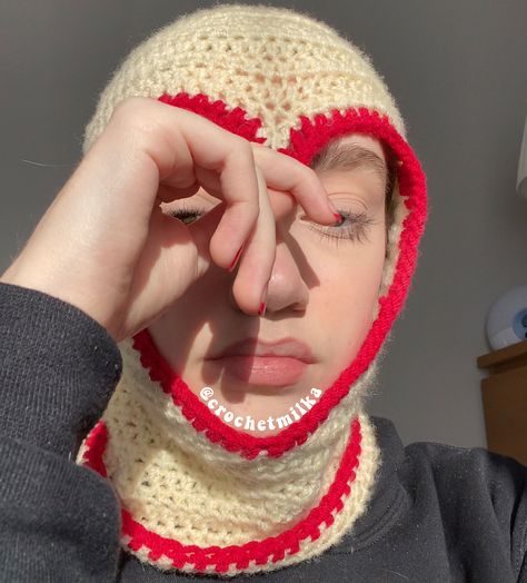 A girl wearing a cream coloured heart cut out crochet ski mask with red lining on the rim of the heart cut out and as well as the opening to the mask. Crochet Full Face Mask, Crochet Heart Balaclava, Free Crochet Ski Mask Patterns, How To Crochet A Ski Mask, How To Style Balaclava, Bonnet Pattern Crochet, How To Crochet Balaclava, Crochet Heart Hat, Crochet Mask Pattern Free