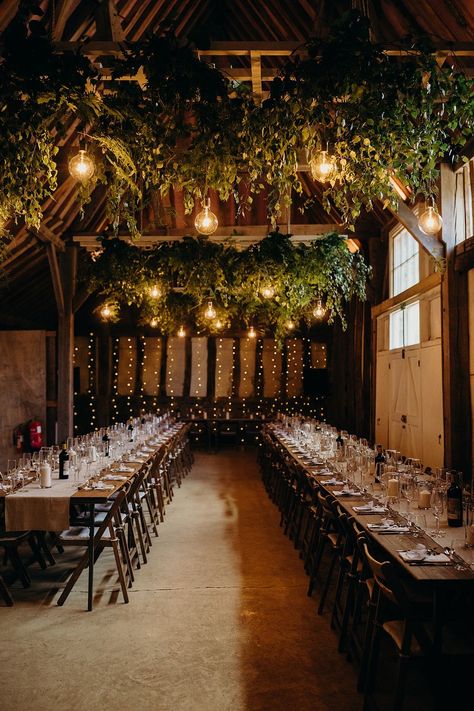 Barn Wedding Greenery Hops Light Bulbs Decor Richard Skins Photography #wedding #barnwedding #weddingdecor Rustic Wedding Greenery, Fairy Lights Wedding Reception Barn, Fairy Lights Wedding Reception Wreaths & Garlands, Greenery And Twinkle Lights Wedding, Rustic Wedding Ceiling Decor, Hanging Foliage Wedding, Barn Party Decor, Barn Reception Decorations, Barn Decorating Ideas