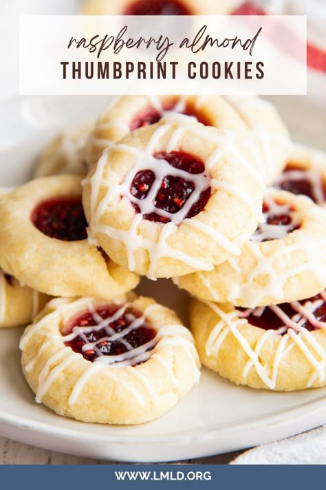 These Raspberry Thumbprint Cookies have a buttery almond shortbread based cookie filled with raspberry jam, and drizzled with a sweet almond glaze. The cookies practically melt in your mouth, and are such a beautiful bite sized cookie. Plum Shortbread Cookies, Berry Shortbread Dreams, Christmas Almond Cookies Recipes, Five Ingredient Raspberry Cheesecake Thumbprint Cookies, Nut Thumbprint Cookies, Raspberry Bow Tie Cookies, Italian Raspberry Cookies, Land O Lakes Raspberry Thumbprints, Raspberry Almond Thumbprint Shortbread Cookies