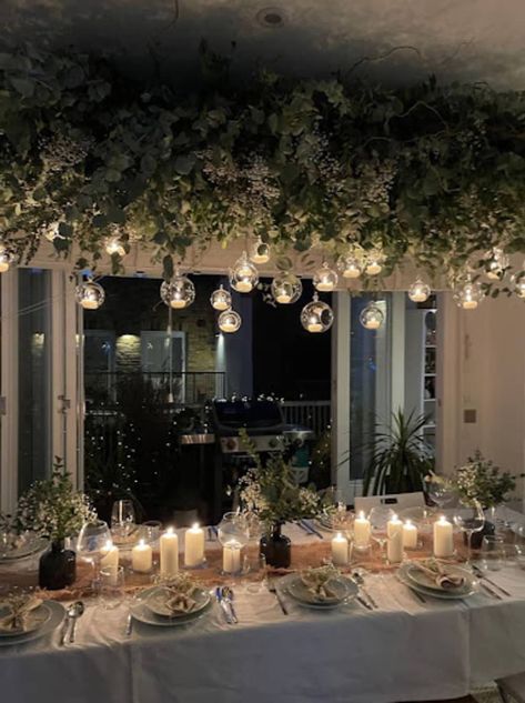 Holiday table with overhead garlands and small lights, candles on table Candle Table Setting, Christmas Table Decorations Diy, Twisted Candles, Table Decoration Ideas, Diy Christmas Table, Christmas Table Decoration, Table Garland, Christmas Interiors, Hanging Garland