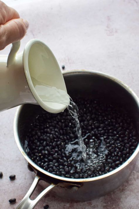 a pot full of dried black beans.  A jug of water is being poured on top of the beans. Soaking Beans, How Long To Soak Beans, How To Cook Dry Beans Fast, Quick Soak Dry Beans, Fast Soak Dry Beans, Canning Dry Beans Without Soaking, How Long To Soak Beans Before Cooking, Quick Soak Beans, Dry Beans Recipe