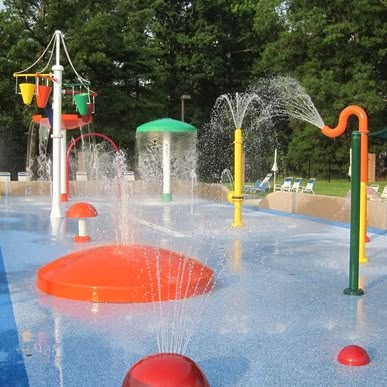 Thinking about making your facility more family friendly for the summer? Try incorporating a splash pad! A splash pad is a great addition to any facility looking to be more competitive with other summer attractions. #americanpool #pools #splashpad #summerattractions #familyfun #poolrenovations #summerfun #activitiesforkids #spraypads #waterplay Water Park Ideas, Backyard Splash Pad, Backyard Water Parks, Spray Park, Park Ideas, Play Structures, Water Playground, Playground Ideas, Splash Park