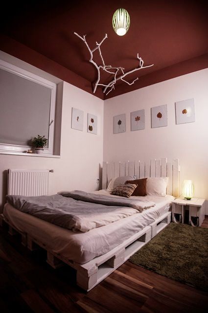 #Bedroom, #Design, #Painted, #PalletBed, #RecycledPallet, #White   Here is a good example of a chic bed installation made out of pallets painted in white. I really love the white branches on the ceiling to finish the concept! Palette Bed Frame, Bed Frame Painted, Bed Made Out Of Pallets, Palette Bed, Pallet Bed Headboard, Wood Pallet Bed Frame, Pallet Bed Frames, Wood Pallet Beds, Pallet Bed Frame