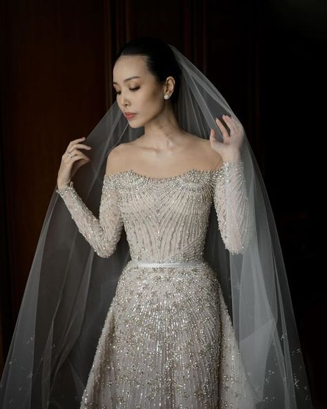 HIAN TJEN on Instagram: "Next level elegance in off-the-shoulder. Silhouette is dazzling, silver beads are glimmering, fitted long sleeves are flawless and draped train detail on the skirt is just gorgeous. The simplicity of the silhouette with the effervescent beads together; a glowing sensation.  #HianTjen #HianTjenBride #HianTjenCouture #Bride #morninglook #weddingdress #embellishment #beadingdress" Hian Tjen, Beaded Dress, Wedding Gown, Silver Beads, Next Level, Wedding Gowns, Off The Shoulder, Wedding Dresses, Long Sleeves