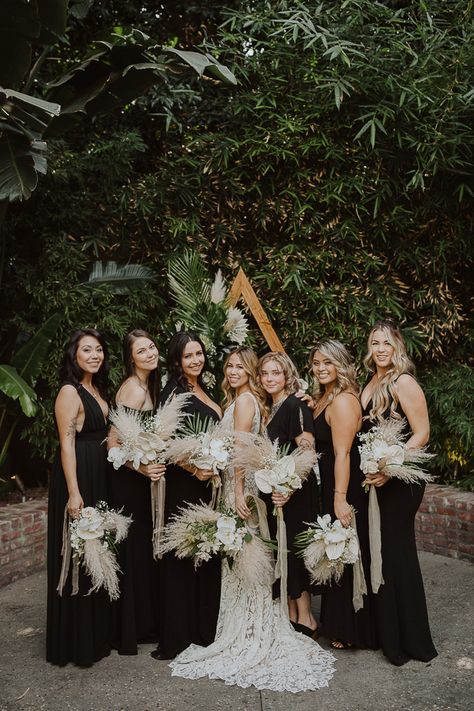 Tropical Industrial Millwick Wedding | Junebug Weddings Black Bridesmaid Dresses Boho Flowers, Dark Boho Bridesmaid Dress, Boho Wedding Black Bridesmaid Dresses, Pampas Grass Wedding Black, Spring Wedding With Black Bridesmaid Dresses, Black Bridesmaid Dresses Tropical Wedding, Different Color Bridesmaid Dresses Boho, Black And Green Boho Wedding, All Black Boho Wedding