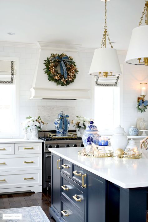 Kitchen island styled for Christmas with ginger jars, candles, ornaments and trays. A large ginger jar on the stove with a blue velvet ribbon is an elegant detail along with a green and gold wreath hung above on the hood. This setting gives a traditional kitchen a classic, elegant feel. Christmas Entryway, Blue Kitchen Decor, Dear Lillie, Thrifty Decor Chick, White Ginger Jars, Christmas Kitchen Decor, Christmas Living Rooms, Elegant Kitchens, Christmas Kitchen