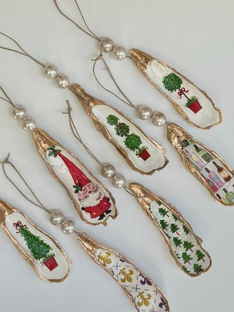 These unique oyster shell ornaments are the perfect gift for a Holiday hostess, ornament party or to add to your Christmas decor! Each shell features a different Holiday image (choose your preferred style from the drop down box). The shells are finished with a gold trim and two hand painted marbled pearl beads to make these ornaments truly unique. Painted Shells Christmas, Gifts With Shells, Turkey Wing Shell Crafts, Clam Shell Ornaments Diy, Oyster Shell Crafts Christmas, Oyster Shell Christmas, Santa Oyster Shell Ornament, Sea Shell Christmas Ornament, Oyster Shell Gifts