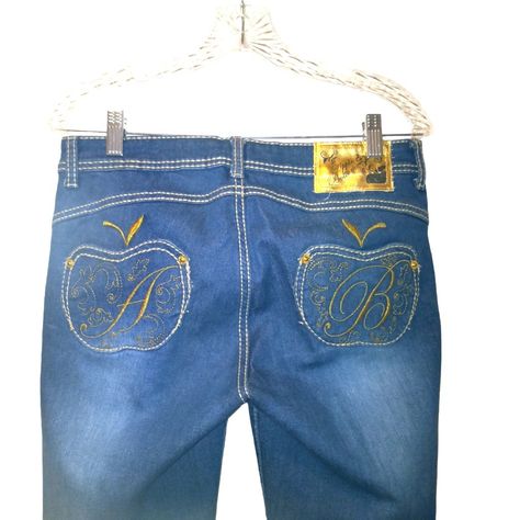 These Vintage Apple Bottom Jeans Are A Must-Have Addition To Any Fashionista's Wardrobe. With A Tapered Leg And Mid-Rise Fit, These Jeans Are Perfect For Any Season. The 5-Pocket Design Features Gold Apple Emblems And Embroidered Details On The Back Pockets, Adding A Touch Of Luxury To The Classic Denim Fabric. The Whiskering And Shading Accents Give These Jeans A Unique And Stylish Look That Is Sure To Turn Heads. Crafted With A Mix Of Spandex And Cotton, These Jeans Are Not Only Comfortable To Apple Bottom Jeans, Apple Bottoms, Gold Apple, Vintage Apple, Bottom Jeans, Embroidered Details, Denim Fabric, Pocket Design, Tapered Legs