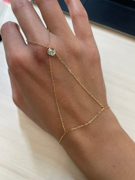 This hand chain features a gold chain across the hand with a bezel set .6ct diamond That lays comfortably above the knuckle. This unique hand candy will stun on your wrist! Available in 14k Yellow Gold, Rose Gold, and White Gold Total Carat Weight: 0.6cts Diamond Color: G Diamond Clarity: SI1 Made to order. Lead time is 2-4 weeks Benefits of 18k Solid Gold Jewelry Most loved for its durability and longevity Can be worn daily and requires less maintenance and care than plated, vermeil, or silver Hand Candy, Hand Chain Jewelry, Hand Harness, Hand Chain Bracelet, Diamond Girl, Permanent Jewelry, Luxe Jewelry, Jewelry Bracelets Gold, Dope Jewelry