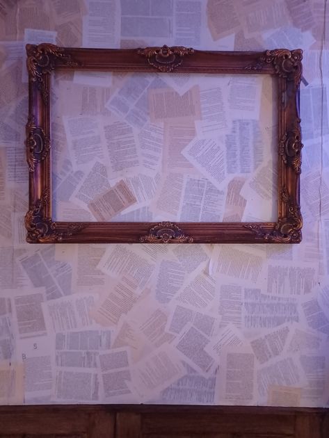 Wall covered in book pages with an empty picture frame in the center Picture Frame Aesthetic, Empty Picture Frames, Empty Frames, Book Aesthetics, Book Pages, Picture Frame, Wall Coverings, Picture Frames, Design Ideas