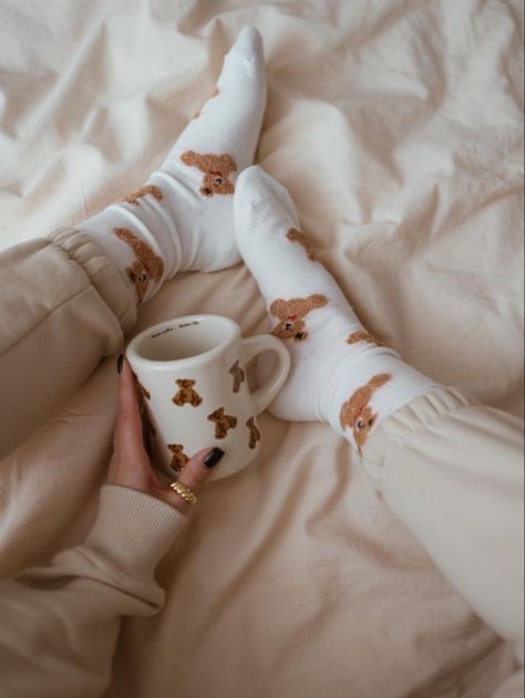 A girl is holding a white mug with teddy bears on it. She has matching socks. 17 Doğum Günü, Teddy Bear Mug, Bear Socks, Socks Aesthetic, Bear Mug, Cute Pjs, Brown Teddy Bear, Beige Outfit, Ideas For Instagram Photos