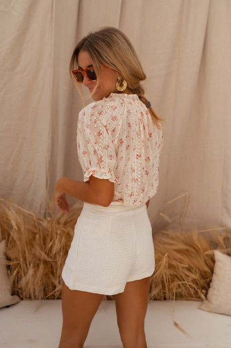 Ecru short sleeve blouse with dainty embroidery all over with peach floral patterns paired with a v-neckline, buttoning tabs up the front in addition the blouse is not lined but is not sheer. This blouse is a summer daydream; so versatile, chic and on trend. Our model wears the Ecru Adrian Shorts Sizes: S-M / M-L S-M: Length 22.83 in - Width 16.93 in M-L: Length 23.62 in - Width 17.72 in Contexture: 100% polyester Washing: handwash recommended or on delicate setting Summer V-neck Blouse With Floral Embroidery, Pretty Feminine Aesthetic, Lisbon Outfits Summer, Peach V-neck Summer Blouse, Summer Romantic Outfits, Summer Peach V-neck Blouse, Summer Outfits Large Bust, Cream Floral Embroidered Summer Tops, Summer Blouse With Floral Embroidery And Short Sleeves