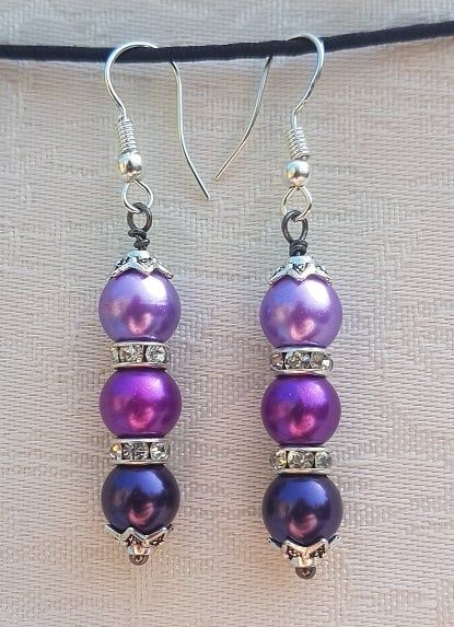 Gorgeous shades of Purple glass pearls separated by clear crystal rondelles and dangling from silver hooks. Beautiful colours for the Summer with a little sparkle. Approx: 2 /14" (5.7cm) long from top of ear wire to bottom of beads. Ear wires are ... Unique Earring Designs, Diy Earrings Dangle, Creative Earrings, Diy Earrings Easy, Beaded Earrings Tutorials, Beaded Earrings Diy, Earrings To Make, Handmade Jewelry Tutorials, Earrings Inspiration