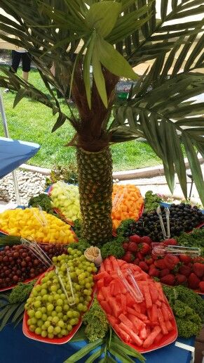 Fruit Displays For Party, Fruit And Vegetable Table Display, Fruit Bar Ideas Parties, Fruit And Flower Table Garland, Fruit Display Ideas For Party, Fruit Display Tables, Entertaining Food Dinner, Jungle Fruit Display, Tropical Fruit Centerpiece Wedding