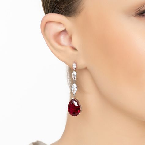 Add a touch of regal elegance to your ensemble with the Zara Teardrop Ruby Earrings in Silver, featuring lab-created rubies. These striking earrings boast a pear-shaped ruby at their heart, set against a backdrop of ornate silver, and are accentuated by a row of three marquis-shaped simulated diamonds for that extra sparkle.  Rubies, with their deep red hue, symbolize passion, courage, and love. Perfect for a glamorous night out or adding a bold statement to your daily attire, these earrings are sure to turn heads. Elevate your jewellery collection with the addition of these mesmerizing ruby earrings and let your style reflect your boldness and elegance. Handcrafted in 925 Sterling Silver. Lab-created Ruby. Simulated Diamonds.  Care Instructions:  To maintain your jewellery, wipe gently wi Red Ruby Earrings, Regal Elegance, Formal Jewelry, Silver Lab, June Birthstone Jewelry, Ruby Earrings, Red Earrings, Pearl Jewellery Earrings, Men's Jewelry Rings