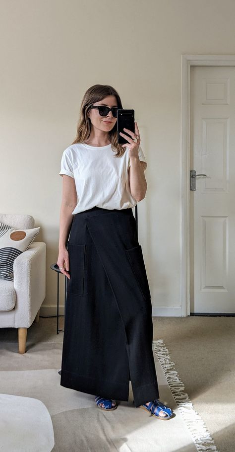 A woman stands in front of a mirror. She wears black sunglasses, a white T-shirt, a long black skirt and blue fisherman sandals. Black Linen Skirt Outfit Summer, Black Linen Maxi Skirt Outfit, Casual Black Skirt Outfit Summer, Black Summer Maxi Skirt, Long Skirt And Shirt Outfits, Black Maxi Skirt Outfit Ideas Summer, Black Maxi Skirt Outfit Summer, Angharad Jones, Skirt With T Shirt