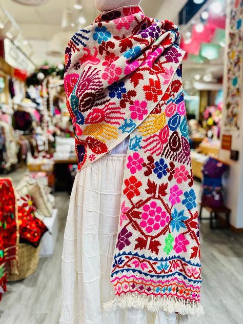 These rebozos, thick Mexican scarves or shawls, are warm, thick and beautifully hand-embroidered. The embroidery is traditional to Hueyapan, Puebla, Mexico, known as the birthplace of the embroidered rebozo. Beautiful knotted finishing details set these rebozos apart. 100% Handmade and Fair-Trade. Available in Cotton and Wool Mexican Clothes Traditional, Mexican Holiday Outfits, Mexican Outfit Traditional, How To Wear A Mexican Rebozo, Rebozo Outfit, Mexican Women Fashion, Huipil Outfit, Guatemala Embroidery, Mexican Scarf