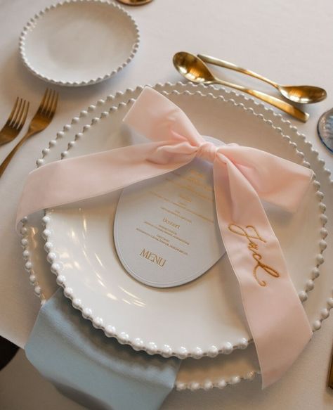 Pretty as a picture wedding table setting // ⁠ ⁠ This elegant wedding table setting perfectly pairs contemporary wedding stationery from London based Letterpress wedding stationer @inkandpaper_ldn with a luxurious name embroidered velvet bow from @theembroiderednapkincompany.⁠ ⁠ ⁠ The chic, oval shaped menu card (in the most delicate shade of pale blue with hot gold foil detailing) and bow embellishment sit atop pearl edged white presentation plates, beautifully elevating the elegance of the ... Romantic Wedding Table Settings, Bow Bouquet, Flowers London, Wedding Table Setting, Desserts Menu, Letterpress Wedding, Menu Card, Contemporary Wedding, Wedding Aesthetic