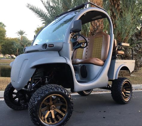 Custom GEM car with hand built 8” lift kit by EV Designs, rear seat kit, roof rack and rear bed side rails all hand built by EV Designs, finished in Nardo gray kevlar finish with chocolate brown upholstery and plaid center inlays, 14” gold MZ rims with 23” all terrain tires. AWESOME CAR!! #custom #customgemcar #customgemcars #ev #evdesigns #elevatedesigns #dustinmacintosh #gemcar #gem #golf #golfcart #golfcar #streetstyle #golfcourse #fab #fabrication #upgrade #elevatedesignscustomgemcars #eleva Gem Cars, Bed Side Rails, All Terrain Tires, Car Golf, Nardo Grey, Cart Ideas, Golf Car, Famous Musicians, All Terrain Tyres