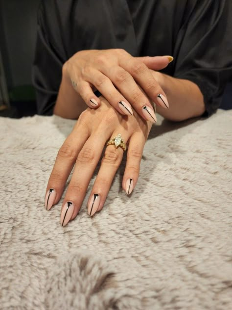 Two relaxed hands, one over the other, palms down to display light pink/nude colored stilleto shaped nails with straight black line detail from tip to cuticle. Light tan fur background. Black Triangle Nails, Vertical Line Nails, Black Fine Line Nail Art, Black Lines Nail Art, Nails With Straight Lines, Black Lined Nails, Black Line Design Nails, Linear Nail Art, Black Nails Lines