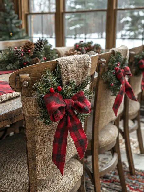 27 Farmhouse Christmas Dining Table Decor Ideas You’ll Love Dining Room Chair Christmas Decoration, Chair Bows Christmas, Chair Christmas Decorations, Farmhouse Christmas Dining Table Decor, Farmhouse Christmas Dining Table, Christmas Chair Decorations, Christmas Dining Table Decor Ideas, Dining Table Decor Ideas, Candle Decorations