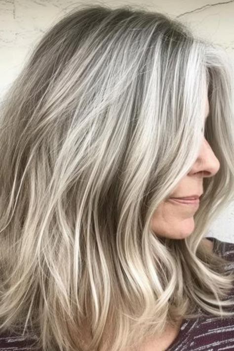 Sandy blonde is a light, muted shade that blends beautifully with gray hair, creating a soft, beachy look. Use a gentle, nourishing shampoo to keep it looking fresh. Click here to check out more where experts and women agree that these colors are perfect or gray hair. Ash Blonde And Gray Hair, Blonde Babylights To Blend Grey, Fall Gray Blonde Hair Color, Gray Hair Highlighted Blonde, Blending Greys Into Brown Hair Blonde, Blonde Highlights Covering Grey, Blond Grey Hair Going Gray, Blond Highlights On Greying Hair, Gray And Platinum Hair