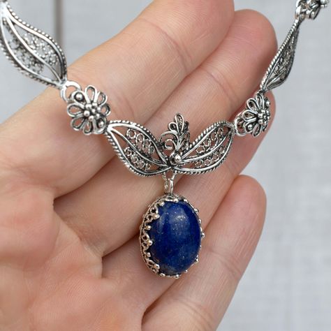 925 Sterling Silver Filigree Art Lapis Lazuli Gemstone Paisley Design Necklace Length is 17.00" and it has a 2.00" extension. It is secured with lobster claw closure. The Lapsi Lazuli gemstone genuine, cabochon cut and dimension is 12X16 mm oval. Lapis Lazuli is a stone that emboldens the communicative abilities between the mind, throat, and heart. One will shortly begin to find themselves radiating the truth of their emotional body. Lapis Lazuli’s energies promote heightened intellect, inner vi Boho Pendant Necklace, Blue Stone Necklace, Floral Pendant Necklace, Lapis Lazuli Jewelry, Princess Necklace, Filigree Necklaces, Lapis Lazuli Gemstone, Filigree Jewelry, Emotional Body