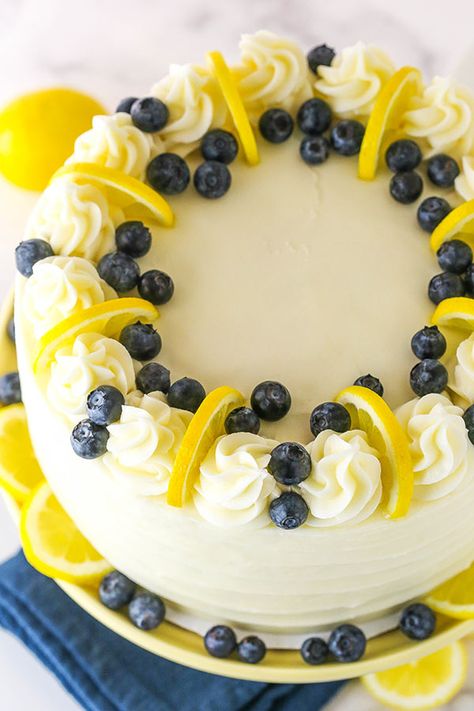 This Lemon Blueberry Layer Cake is bursting with fresh blueberries and lemon flavor. Topped with cream cheese frosting, this cake is perfect for Summer! #lemoncake #blueberrycake #summerdessert Lemon Blueberry Layer Cake, Blueberry Layer Cake, Blueberry Lemon Cake Recipe, Coconut Blueberry, Blueberry Yogurt, Lemon Poppyseed Cake, Blueberry Cake Recipes, Cookies Bars, Blueberry Lemon Cake