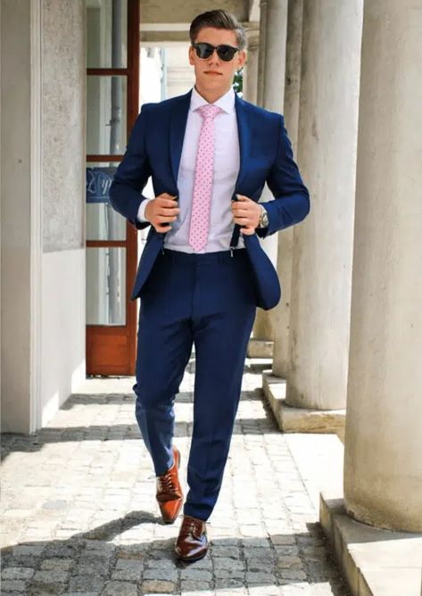 23 Best Pink Outfit Ideas for Men with Styling Tips Light Blue Suit With Pink Shirt Men, Blue Pink Suit Men, Dark Blue Suit With Pink Tie, Navy Blue And Pink Suit Men, Blue Suit With Pink Shirt Men, Pink Sport Coat Men Outfit, Pink Tie Outfit Men, Light Pink Shirt Outfit Men Formal, Blue Suit Pink Shirt