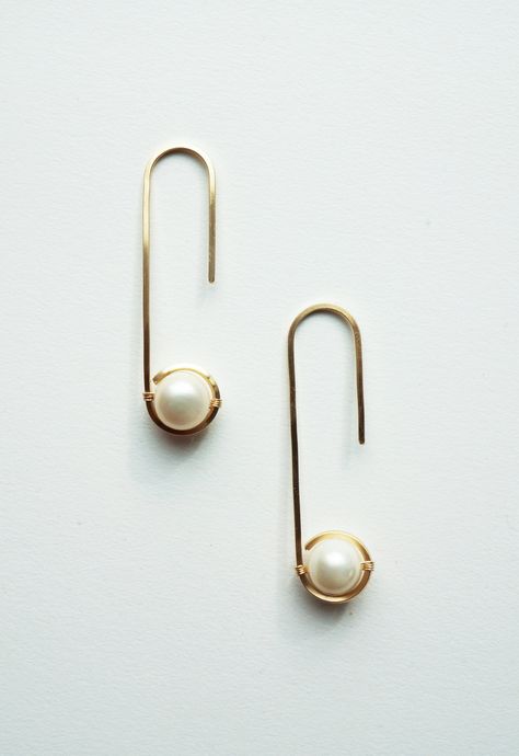 "Aperta is the latin word for \"open.\" These simply beautiful oval hoop earrings highlight genuine saltwater pearls by square wire hugging them. Handmade Gold filled or sterling silver square wire Genuine semi-precious cultured Biwa pearls Size: 1-3/4\"L x 7/16\"W Please Note: Due to the natural state of pearls used by Brave Chick, each piece will vary. The naturally occurring variations such as shape, color, shading, color concentration, thickness, texture, are to be expected. These difference Minimalist Wire Earrings, Modern Pearl Earrings With Ear Wire For Everyday, Classic Hoop Earrings With French Hook As Gift, Classic Hoop Earrings With French Hook For Gift, Modern Pearl Earrings With Ear Wire As Gift, Color Shading, Handmade Hoop Earrings, Latin Word, Oval Hoop Earrings