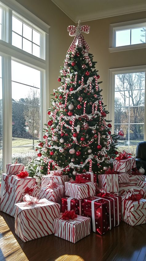 Candy cane-themed Christmas tree with red and white ornaments, surrounded by gifts in a bright, festive room. Gift Under Christmas Tree, Under Christmas Tree Decor Ideas, Christmas Gifts Under Tree, Candy Cane Theme Christmas, Gifts Under Christmas Tree, Candy Cane Christmas Theme, Red White Christmas Decor, Candy Cane Christmas Decorations, Gifts Under The Christmas Tree