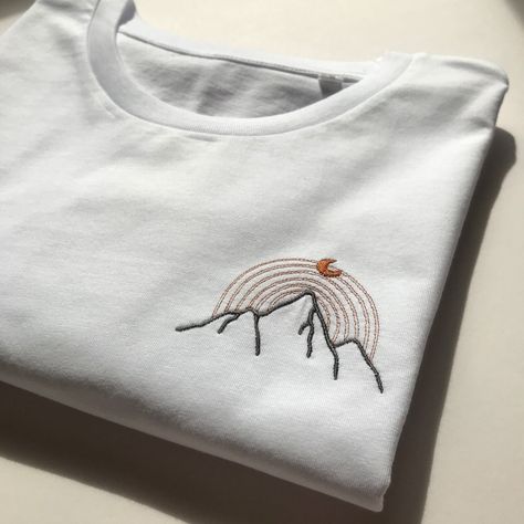 "This unisex pure white t-shirt, with minimalist mountain embroidery on the left chest, is a premium-quality tee designed to be an ideal gift for outdoor adventurers and nature lovers, perfect for camping or nature walks. It will be a unique gift for yourself or your loved ones and family members. Made from 100% organic cotton this super-soft unisex t-shirt is a perfect companion for your next natural adventures. * 100% organic ring-spun cotton * Fabric weight: 5.3 oz/yd² (180 g/m²) * Medium fit * Sustainably and ethically produced * Blank product sourced from Bangladesh, responsibly and ethically made *The embroidery measures approx. 5.5 cm high by 7,5 cm wide overall * The size chart is available in the last photo. For the best size, you can measure your favorite sweatshirt on a flat sur Embroidery Designs For Men Shirt, Male Embroidery Designs, T Shirt Embroidery Ideas For Men, Embroidery Designs For T Shirts, Embroidery Patterns For Men, Men Embroidery Designs, Men Embroidery Shirts, Embroidery Designs Men, Shirt Embroidery Ideas For Men