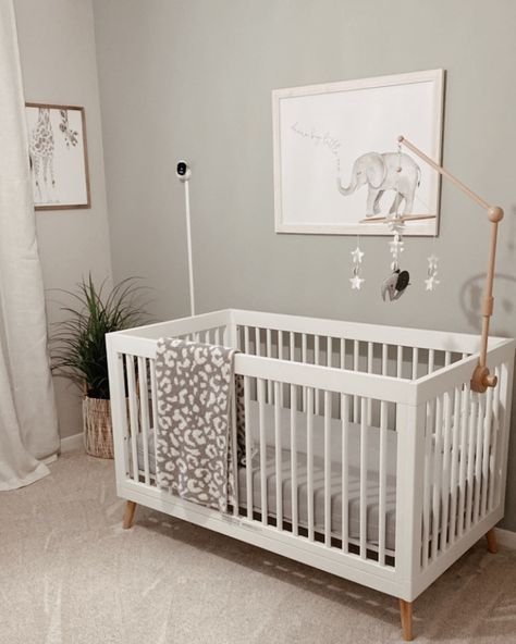 Paint a simple and neutral room for your baby with this nursery accent wall idea. Hang a cute animal drawing on each side of the wall. Finally, add a stylish baby crib with a white and wood elephant mobile just in front of the wall to complete the space.