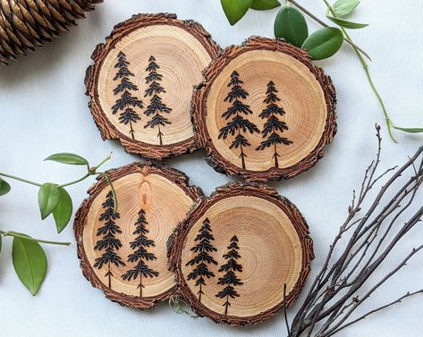 A set of four (4) woodburned coasters. Each one with a unique set of trees!  They are hand-burned on locally sourced, live edge Douglas-fir rounds. The coasters are then finished with 2 coats of a clear polycrylic for wood protection against heat and moisture from various beverages!  Coasters have beautiful natural live-edge bark, and are of course perfectly flat. This set is the perfect addition to any table, desk, or home!  **Each piece of wood is unique, and each tree is hand drawn and burned Wood Burning Ideas Coasters, Coaster Wood Burning, Wood Burning Designs Coasters, Small Wood Rounds Crafts, Woodburned Coasters, Pyrography Coasters, Wood Slice Coasters, Wood Burn Coasters, Wood Burning Trees