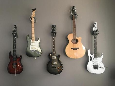 Is hanging your guitar or bass safe? This article explains the reasons why guitar hangers work well. String tension and humidity are addressed. Guitar Hanging Ideas, Studio Music Room, Hanging Guitars, Guitar Hangers, Music Room Design, Guitar Storage, Guitar Display, Home Music Rooms, Music Rooms