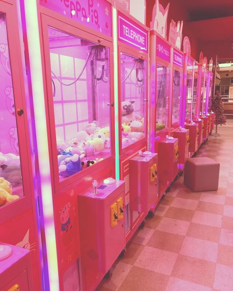 Pink claw machines lined up in a pink arcade Pink Nerdy Aesthetic, Pink Gamer Wallpaper, Pink Arcade Aesthetic, Pink Game Aesthetic, Pink Video Game Aesthetic, Pink Tech Aesthetic, Pastel Arcade, Cute Claw Machine, Pink Apocalypse