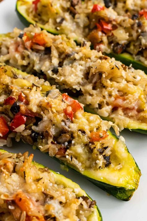 Vegetarian stuffed zucchini with onions, peppers, mushrooms, & rice is topped with Parmesan & baked to perfection for a tasty meat-free meal! Stuffed Zucchini Recipes Vegetarian, Vegetarian Stuffed Zucchini, Vegetarian Zucchini Recipes, Vege Dishes, Zucchini Rice, Eggplant Zucchini, Cauliflower Soup Recipes, Mushroom Rice, Stuffed Zucchini