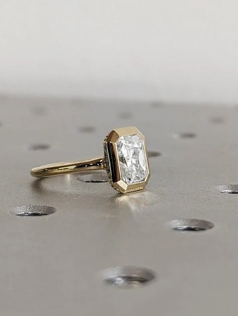 MAIN STONE
Type: Braverman Moissanite
Cut: Radiant
Color: D
Clarity: VVS

#1.5ct #Radiant #Cut #Moissanite #Solitaire #Bezel #Setting #Engagement #Ring #14K #Yellow #Gold #Diamond #Hidden #Halo #Promise #Ring #Statement #Ring #anniversary #ring #engagement #ring #promise #ring #statement #ring #wedding #ring #yellow #gold #ring #bezel #set #ring #radiant #moissanite #moissanite #gold #ring #moissanite #solitaire #gift #for #her #hidden #halo #ring #unique #ring Bezel Setting Engagement Ring, Radiant Cut Hidden Halo, Ring Images, Wedding Ring Yellow Gold, Engagement Ring Types, Eternity Diamond Band, Radiant Moissanite, Personalized Wedding Rings, Hidden Halo Ring