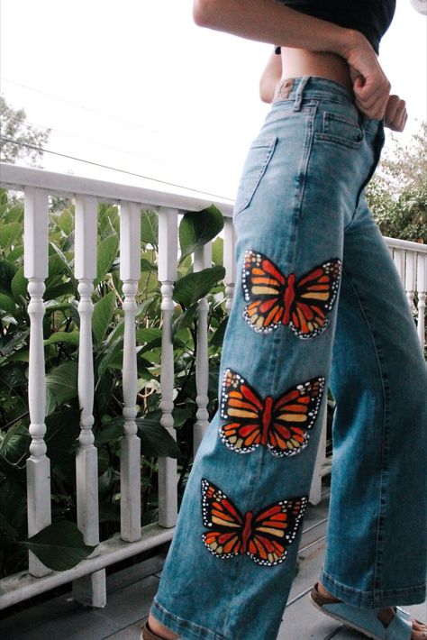 In this pin there is a girl in a pair of jeans on a front porch. The jeans are a medium/light blue tone with three monarch butterflies painted vertically down the right leg. Hand Painted Jeans, Custom Jeans Diy, Painted Clothes Diy, Comfy Casual Outfits, Custom Jeans, Painted Jeans, Cute Pants, Butterfly Effect, Painted Clothes