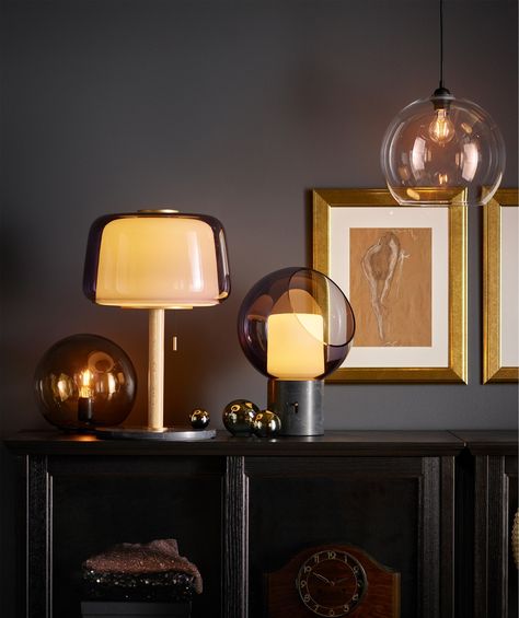 EVEDAL and FADO table lamps clustered on a cabinet, next to gold framed pictures.