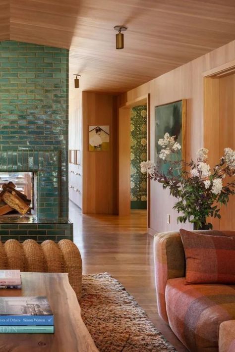 The retro, earthy color palette of this recently renovated riverhouse is a nod to its 1970s past. Each of the rooms abundantly feature various natural wood tones to envelope the house in a cozy yet luxurious feel that harkens back to the 1970s feel of the original home. To balance out the warm tones in the living room, a beautiful family of blues and turquoises were introduced 

Image credit: JHID / Photography Aaron Leitz / TaylorSmith Sustainable Construction 1960s Ranch House Interior, 70s Stone Fireplace, 1970s House Interior, Son House, 1970s House, Vaulted Ceiling Living Room, Sustainable Construction, Earthy Living Room, House Redesign