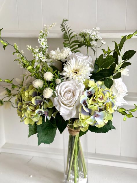 White and green hand tied silk flower arrangement including beautiful roses, hydrangea, queen Anne's lace, thistle and greenery.  *Vase not included, price is for flowers and greenery only* The flowers are secured with florist tape and bound with natural twine, ready to place straight into a vase.   This arrangement is approximately 56cm high and 40cm wide. The stems of the bouquet measure approximately 21cm from the tying point to the bottom end of the stem. The width of the stems at the tying Greenery Vase, Flower Tie, Flowers Vase, Queen Anne's Lace, Flowers And Greenery, Queen Annes Lace, Silk Flower Arrangements, Green Hand, Artificial Flower Arrangements