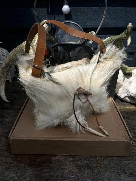 My first ever handcrafted bag 😻 I think I'm in love. This is a goat hide with a goat leg featured on top. Look at the little Mohawk hair down the middle 🥺 It has a repurposed long leather shoulder strap with and a pretty antler tip toggle closure.  Thank you @misery_farm for this beautiful goat fur 🤍  Goat leg supplied by @theforestwitch6 🐐  #goat #goathide #goatbag #handcrafted #bag Goat Leg, Beautiful Goat, Mohawk Hair, Mohawks, T Bag, Diy Clothes Design, Fur Bag, Handcrafted Bags, Cat Bag